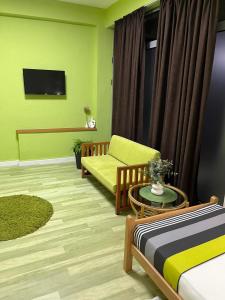 a living room with a couch and a tv at Green Apartment in Strumica