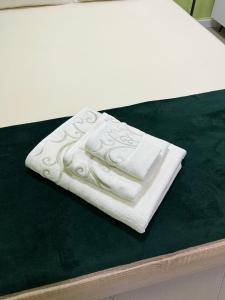 Green Apartment في ستروميكا: بطانية بيضاء تجلس فوق السرير