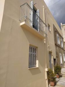 a white building with a balcony and a window at Seaside Serenade 1, suite in Ermoupoli