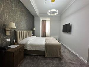 Imperial Palace Hotel Yerevan tesisinde bir odada yatak veya yataklar