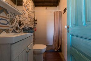 uma casa de banho com um WC, um lavatório e uma porta azul em Casa da Avó Emília em Arganil