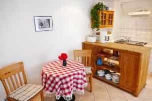 uma cozinha com uma mesa com uma toalha de mesa vermelha e branca em Bungalow Kopp em Bansin
