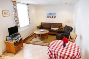 uma sala de estar com um sofá e uma mesa em Bungalow Kopp em Bansin