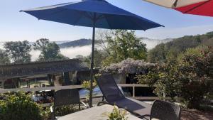 a table and chairs with an umbrella on a patio at O'jardin in Arthez-de-Béarn