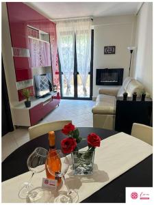 Eva Le Residenze في Marco Simone: طاولة مع زجاجة من النبيذ والزهور عليها