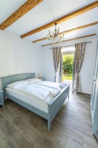 a bedroom with a large bed and a chandelier at Amalija Apartments in Strunjan