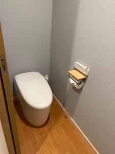 baño con aseo blanco en una habitación en Pension Bonnard, en Hakuba