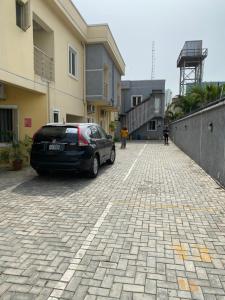 a car parked in a parking lot next to a building at JEFA Deluxe Suites in Lagos