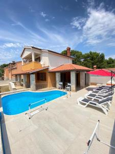 a house with a swimming pool in front of a house at Villa Family in Medulin