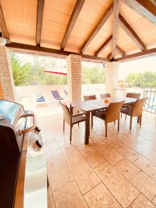 a dining room with a table and chairs on a patio at Villa Family in Medulin