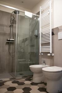 La salle de bains est pourvue de toilettes et d'une douche en verre. dans l'établissement BeTurin, à Turin