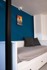 Ce lit se trouve dans un dortoir doté d'un mur bleu. dans l'établissement BeTurin, à Turin