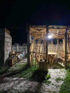 een houten paviljoen met een tafel en een bank in de nacht bij Sevan Hotel in Sevan