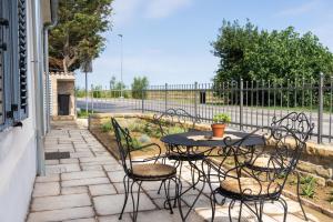 patio ze stołem, krzesłami i ogrodzeniem w obiekcie Amalija Apartments w mieście Strunjan