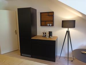 un armario negro con una mesa y una lámpara en Appartment Schloss-Zeit, en Aschau im Chiemgau
