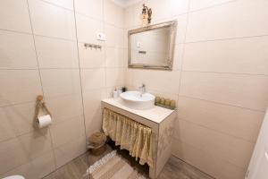 bagno bianco con lavandino e specchio di Amalija Apartments a Strunjan