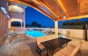 un patio con una mesa y una piscina en Villa Kate, en Trogir
