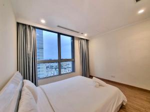 um quarto com uma cama e uma grande janela em Happy Homes - Vinhomes Central Park em Ho Chi Minh