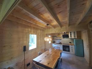 a dining room and kitchen with wooden walls and a wooden table at Warchały Lake House in Warchały +45 photos