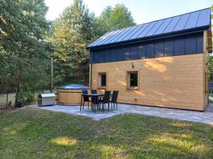 a house with a table and chairs in front of it at Warchały Lake House in Warchały