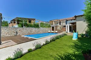 une arrière-cour avec une piscine et une maison dans l'établissement Stone villa with pool, à Galovac