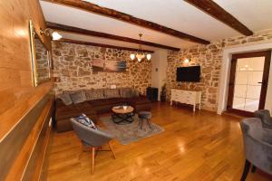 - un salon avec un canapé et une télévision dans l'établissement Stone villa with pool, à Galovac