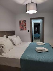 a bedroom with a large bed with two towels on it at White Boutique Homes - Serenity in Metókhion Apisianá