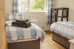a bedroom with two beds and a window at Edge View Cottage in Church Stretton