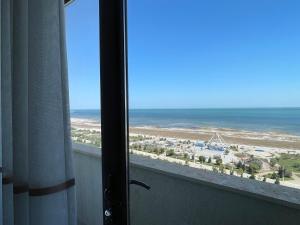 uma vista para a praia a partir de um quarto com uma janela em Caspian Pearl Residence em Sumqayıt