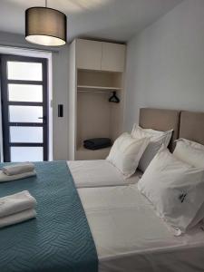 a bedroom with a large bed with white sheets and pillows at White Boutique Homes - Serenity in Metókhion Apisianá