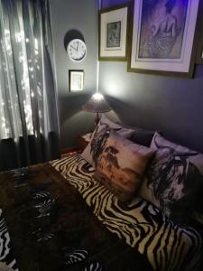 a bedroom with a bed and a clock on the wall at Moeg Geploeg Lodge in Port Shepstone