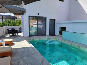 a swimming pool in the backyard of a house at White Boutique Homes - Serenity in Metókhion Apisianá