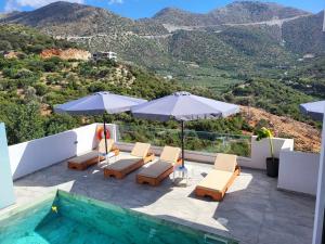 a patio with chairs and umbrellas and a swimming pool at White Boutique Homes - Serenity in Metókhion Apisianá