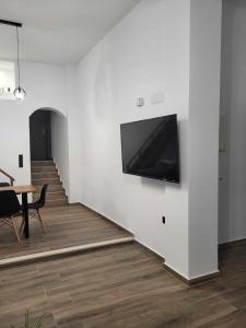 a living room with a television on a wall at White Boutique Homes - Serenity in Metókhion Apisianá +40 photos