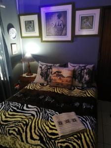 a bedroom with a bed with a zebra print blanket at Moeg Geploeg Lodge in Port Shepstone
