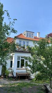 a white house with a picnic table in front of it at villa apartment with sea view in Copenhagen