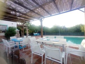 un patio con mesa, sillas y piscina en Casa rural la Estrella en Pizarra