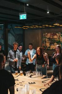 a group of people standing around a table at Next House Copenhagen in Copenhagen