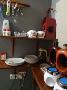 a kitchen counter with plates and dishes on shelves at Moeg Geploeg Lodge in Port Shepstone