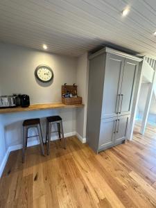 a kitchen with two stools and a clock on the wall at Mulberry Barn located in the South Downs National Park in Ditchling