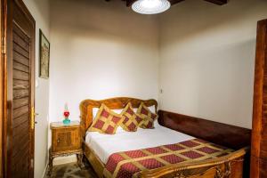 a bedroom with a bed with a wooden headboard at Stonehouse in Selçuk