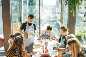 a group of people sitting around a table in a restaurant at Next House Copenhagen in Copenhagen