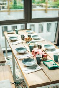 a wooden table with plates and bowls on it at Next House Copenhagen in Copenhagen