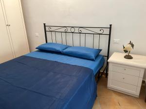 a bedroom with a bed with blue sheets and a night stand at La Dimora del RE in Gaeta