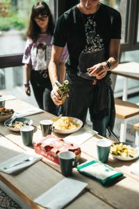 a man standing in front of a table with food at Next House Copenhagen in Copenhagen