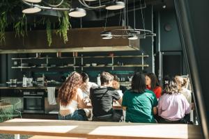 a group of people sitting at a table in a restaurant at Next House Copenhagen in Copenhagen
