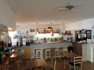 un bar in un ristorante con tavoli e sedie in legno di Malì Trevignano Piccolo Hotel a Trevignano Romano