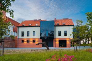 a house with a red roof and a blue at Warmia Apartments in Olsztyn