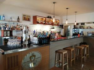 un bar con varias botellas de alcohol y taburetes en Malì Trevignano Piccolo Hotel, en Trevignano Romano