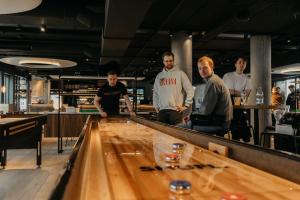 a group of men standing around a bowling alley at Next House Copenhagen in Copenhagen